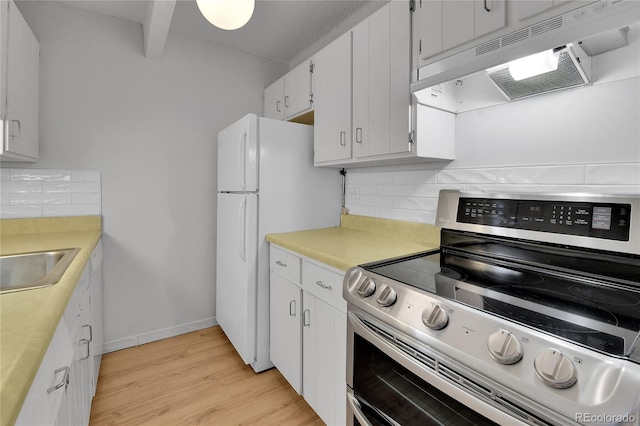8060 E Girard Ave Unit 514, Denver, CO 80231 - kitchen with stainless steel range with electric cooktop, under cabinet range hood, decorative backsplash, and light wood-style floors