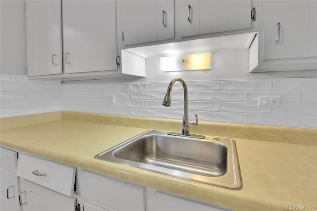 8060 E Girard Ave Unit 514, Denver, CO 80231 - kitchen featuring light countertops, white cabinets, and decorative backsplash