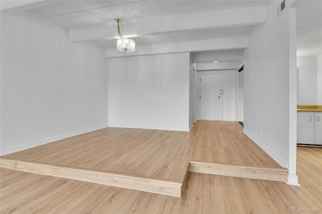 8060 E Girard Ave Unit 514, Denver, CO 80231 - unfurnished room with a textured ceiling, a chandelier, and wood finished floors