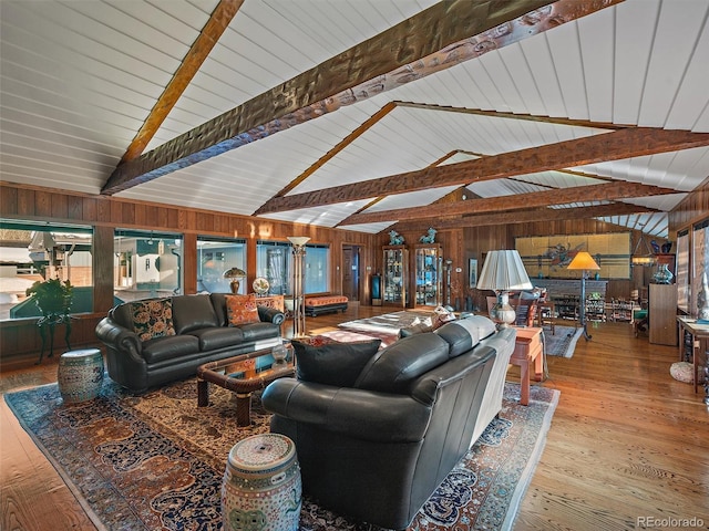 living room featuring beamed ceiling, high vaulted ceiling, wooden walls, and wood-type flooring