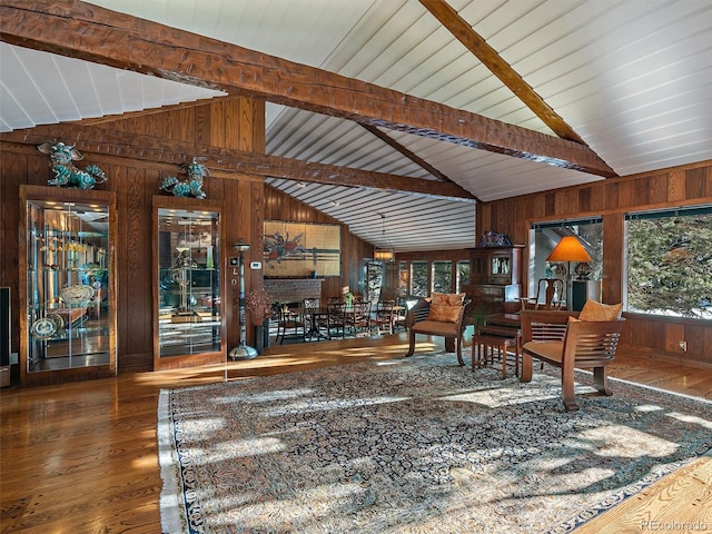 interior space with dark hardwood / wood-style floors, wooden walls, beam ceiling, and high vaulted ceiling