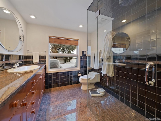 bathroom with tile floors, tile walls, backsplash, vanity, and toilet