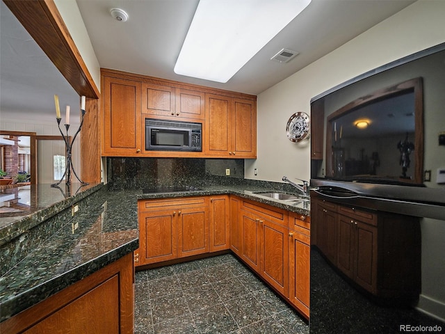 kitchen with dark tile floors, sink, backsplash, and black appliances