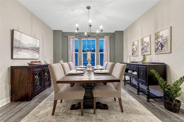 dining area with a chandelier, baseboards, and wood finished floors