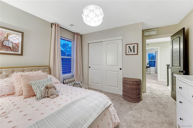 bedroom featuring a closet, visible vents, and light carpet