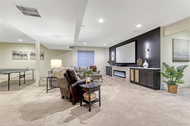 living room featuring recessed lighting, visible vents, a glass covered fireplace, and light colored carpet