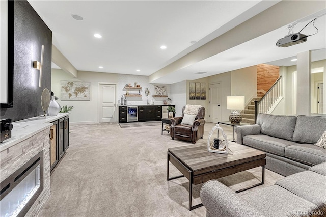 living area featuring a dry bar, light carpet, stairway, a fireplace, and recessed lighting