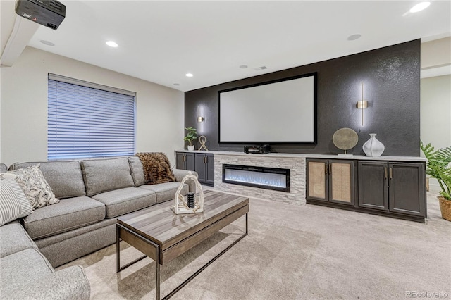 cinema featuring a glass covered fireplace, light colored carpet, and recessed lighting