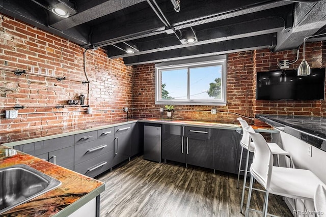 201 Lamkin St Unit 204, Pueblo, CO 81003 - kitchen featuring gray cabinets, dark wood-type flooring, brick wall, refrigerator, and light countertops