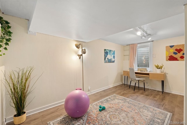 workout area featuring hardwood / wood-style floors and built in desk