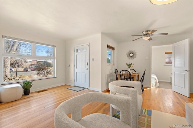 entrance foyer featuring a ceiling fan, baseboards, visible vents, and light wood finished floors