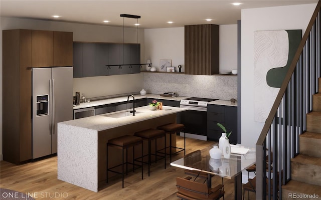kitchen with light wood finished floors, modern cabinets, appliances with stainless steel finishes, a sink, and a breakfast bar area