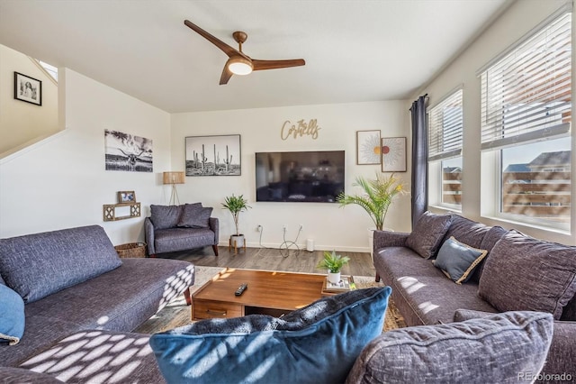 living room featuring wood finished floors, a ceiling fan, and baseboards