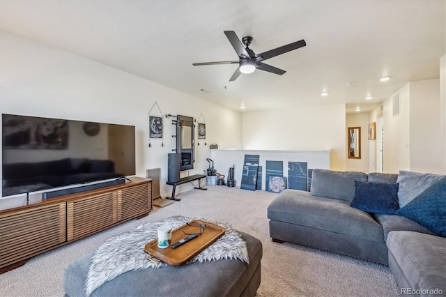 living room with light carpet, visible vents, and a ceiling fan