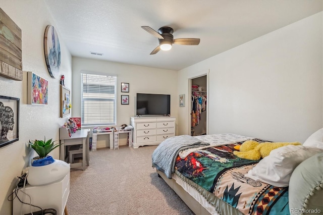 bedroom featuring visible vents, ceiling fan, a walk in closet, carpet floors, and a closet