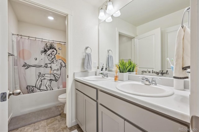 bathroom featuring double vanity, a sink, toilet, and shower / bath combo with shower curtain