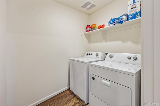 clothes washing area featuring laundry area, visible vents, baseboards, dark wood-type flooring, and separate washer and dryer