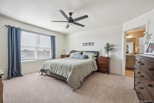 bedroom featuring ceiling fan, baseboards, connected bathroom, and light colored carpet