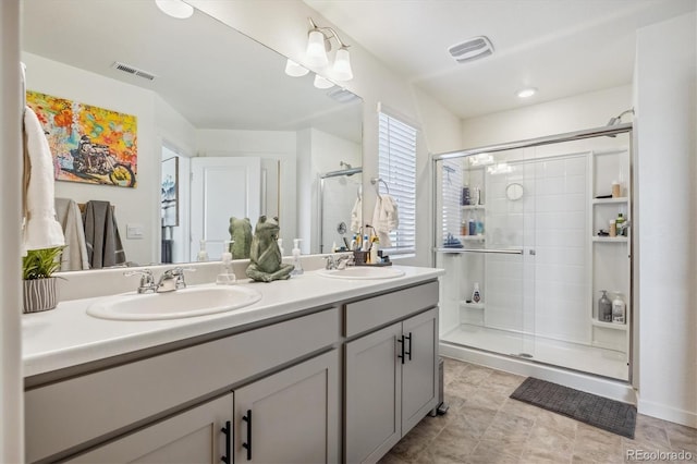 full bath with a sink, visible vents, and a shower stall