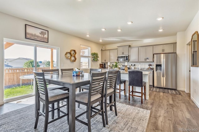 dining space with light wood-type flooring, baseboards, and recessed lighting