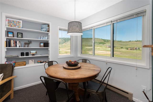 dining area with a baseboard heating unit, a textured ceiling, and carpet flooring