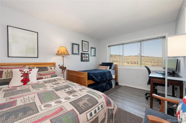 bedroom with a textured ceiling and hardwood / wood-style flooring