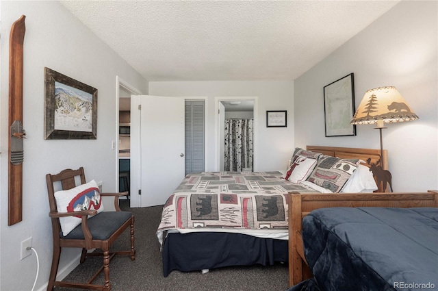 bedroom with carpet, ensuite bathroom, and a textured ceiling