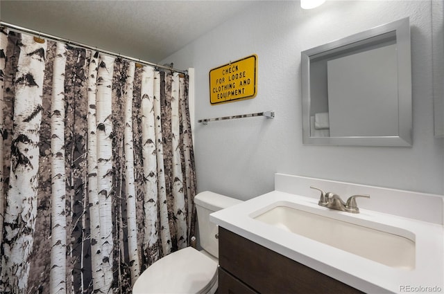 bathroom featuring vanity, a textured ceiling, toilet, and walk in shower