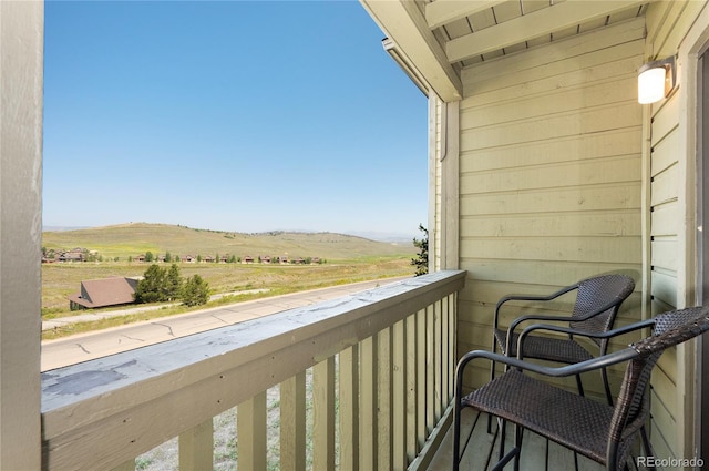 balcony featuring a rural view and a mountain view