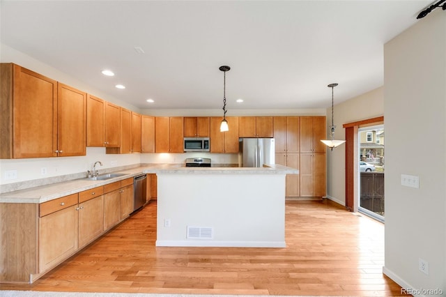22813 E Briarwood Pl, Aurora, CO 80016 - kitchen featuring appliances with stainless steel finishes, light wood-style floors, light countertops, pendant lighting, and recessed lighting