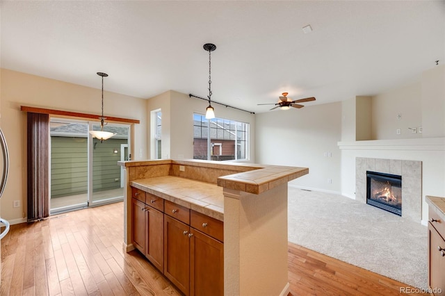 22813 E Briarwood Pl, Aurora, CO 80016 - kitchen featuring tile countertops, ceiling fan, brown cabinets, and decorative light fixtures