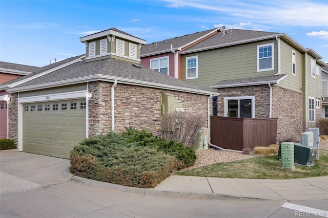 22813 E Briarwood Pl, Aurora, CO 80016 - view of front facade featuring stone siding, driveway, a shingled roof, and an attached garage