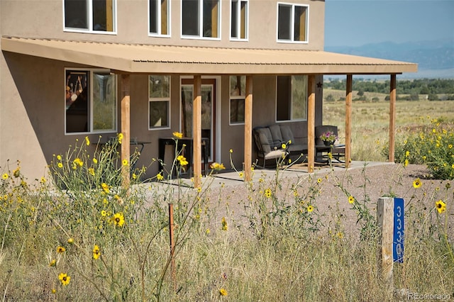 doorway to property with an outdoor living space and a patio