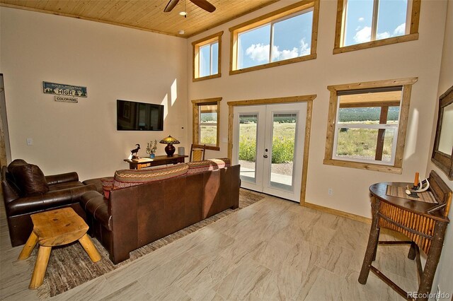 living room with ceiling fan, a high ceiling, french doors, and wood ceiling