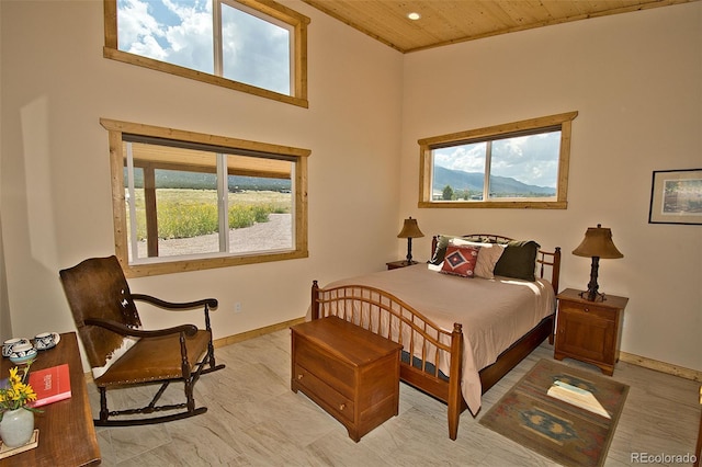 bedroom featuring wood ceiling and a towering ceiling