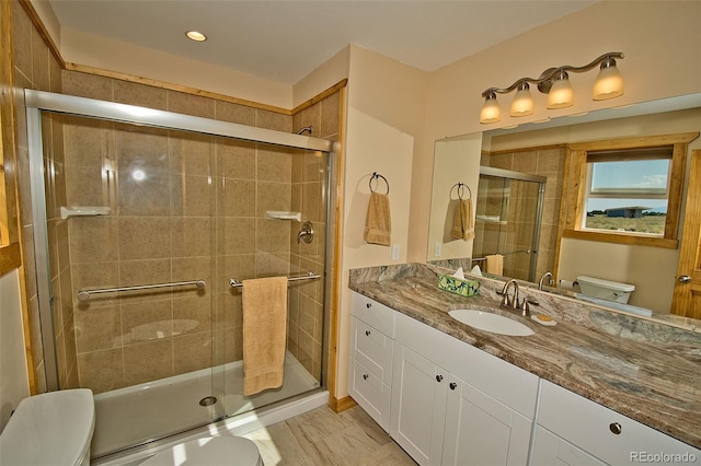 bathroom featuring vanity, toilet, and an enclosed shower