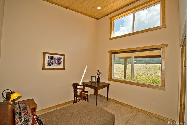 sitting room with a healthy amount of sunlight, wood ceiling, and a towering ceiling