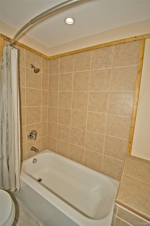 bathroom featuring toilet, tile patterned floors, and shower / bath combination with curtain