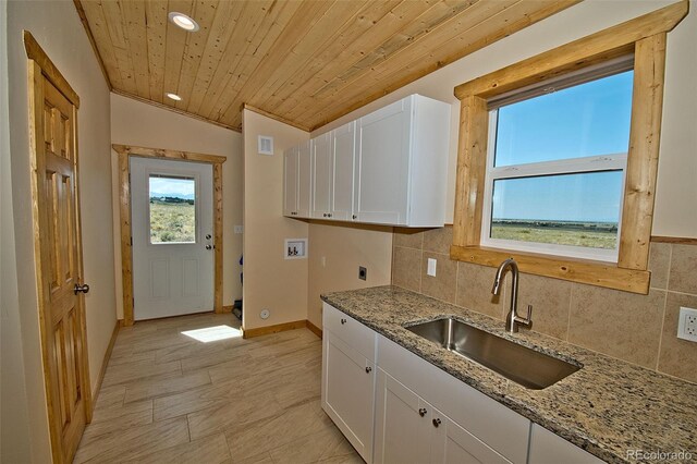 kitchen featuring wood ceiling, sink, backsplash, and white cabinetry