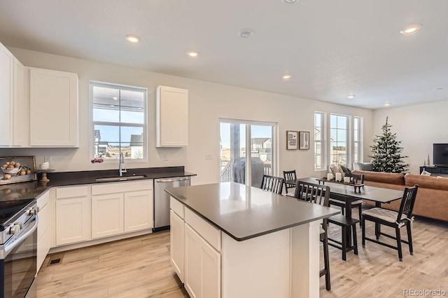 kitchen featuring white cabinetry, sink, stainless steel appliances, and light wood-type flooring