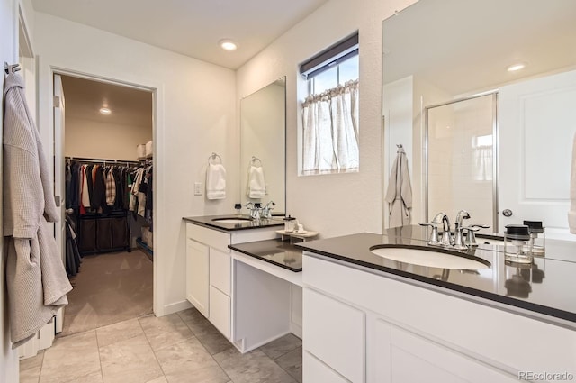 bathroom featuring a shower with door and vanity