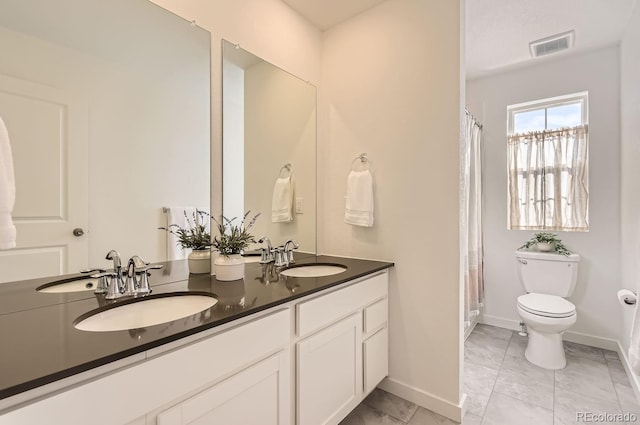 bathroom featuring tile patterned floors, vanity, and toilet