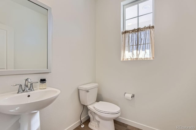 bathroom featuring wood-type flooring, toilet, and sink