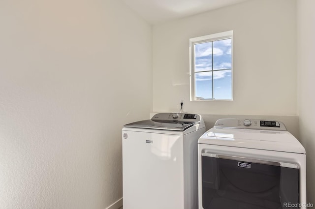 clothes washing area with washer and clothes dryer