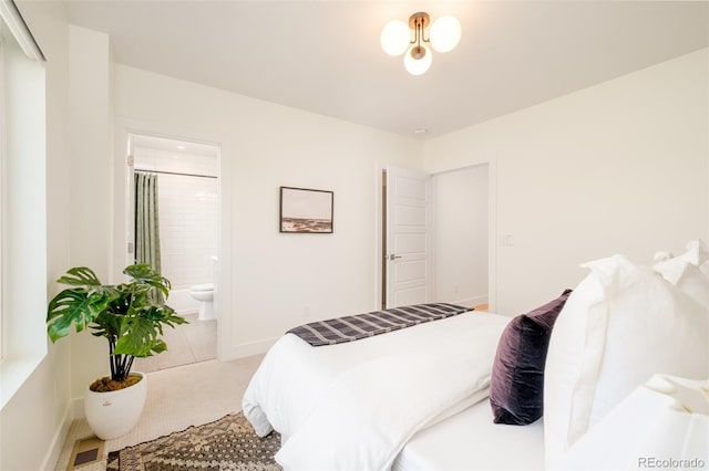 bedroom with ensuite bathroom and carpet