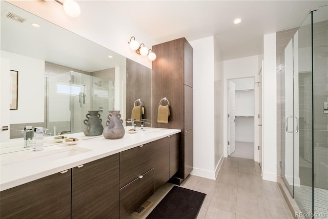 bathroom with an enclosed shower, vanity, and tile patterned flooring