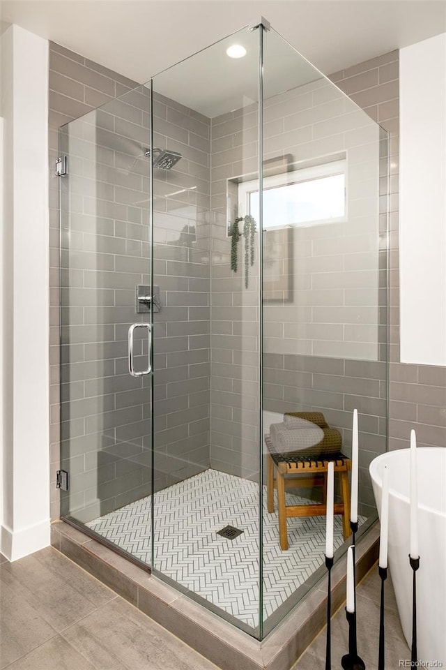 bathroom featuring tile patterned flooring and shower with separate bathtub