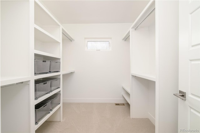 walk in closet featuring light colored carpet