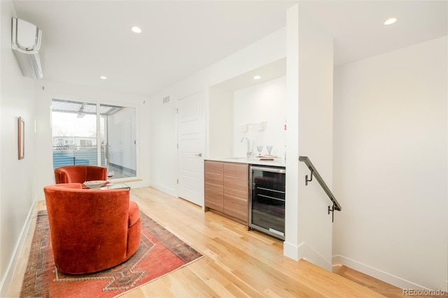 bar with wine cooler, sink, and light hardwood / wood-style floors