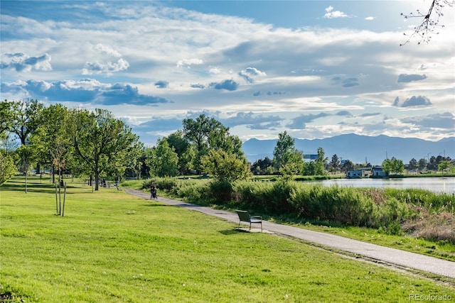 view of property's community featuring a yard and a water and mountain view